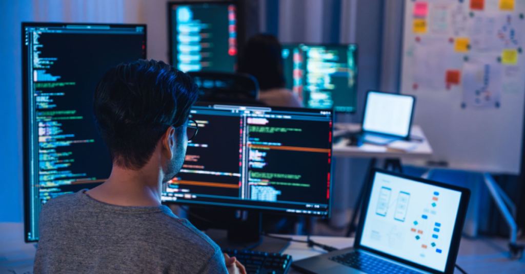 A professional working on AI prompt engineering with multiple screens displaying code and diagrams.